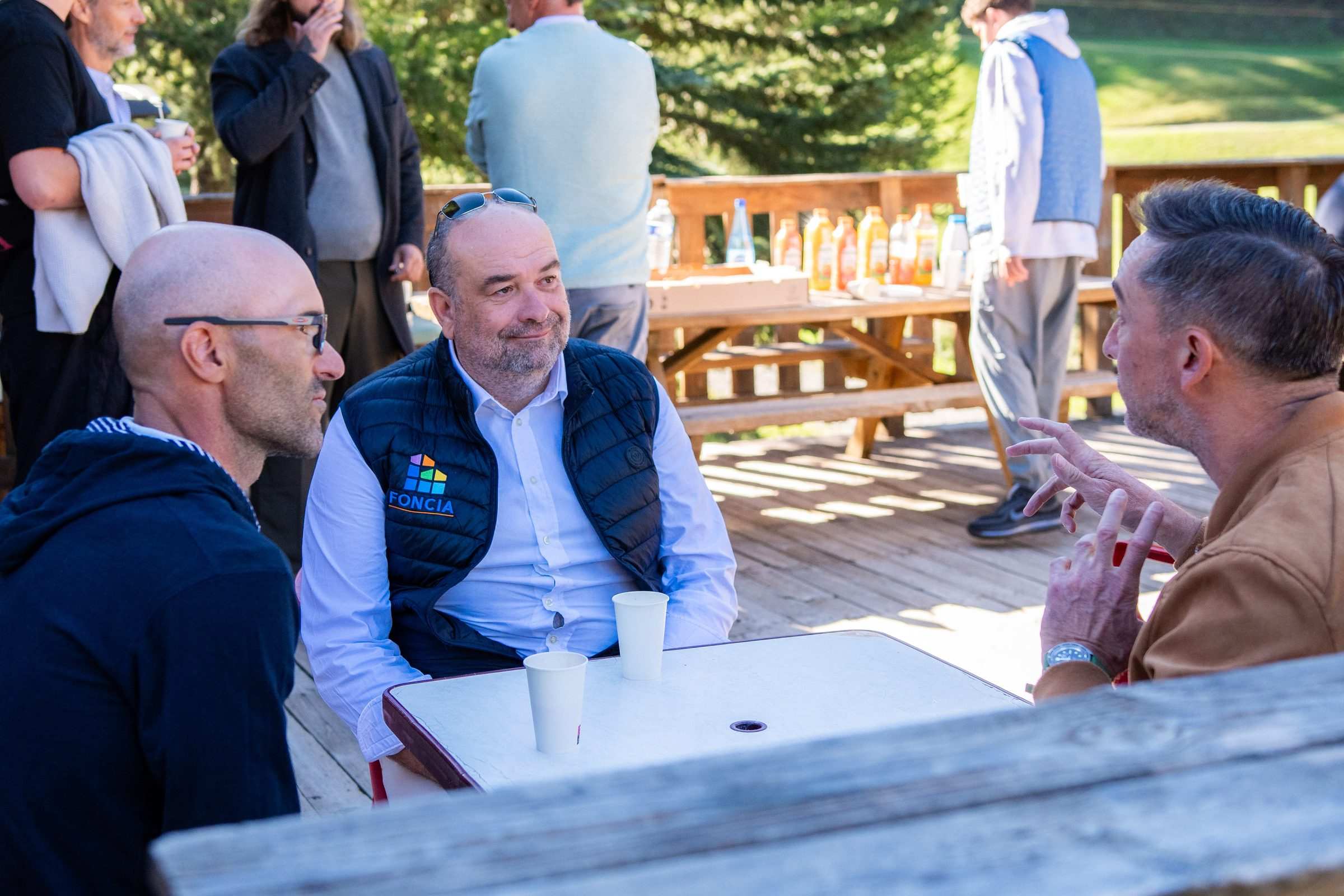 Échange à trois autour d’une table, café à la main