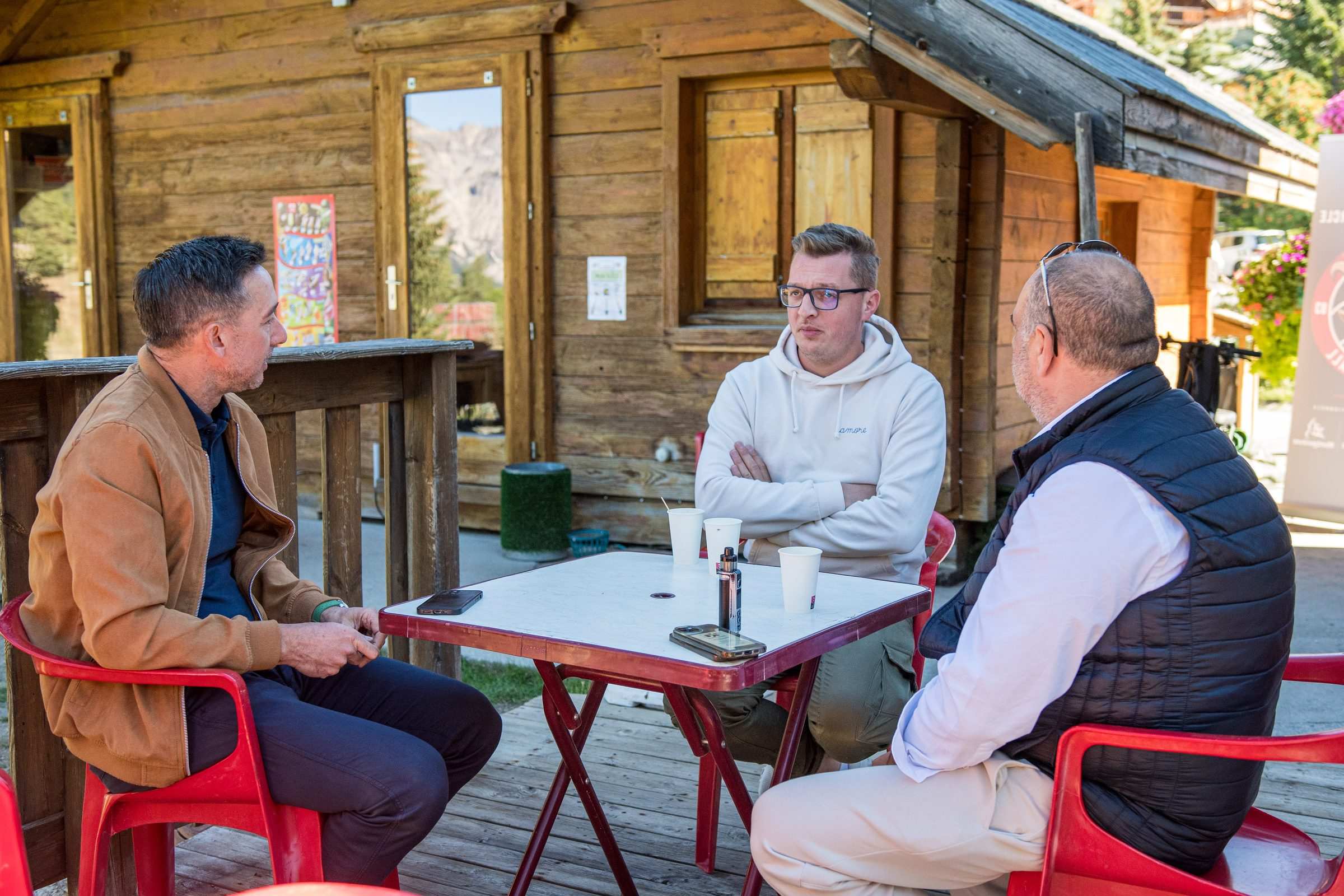 Trois participants assis devant le chalet du golf