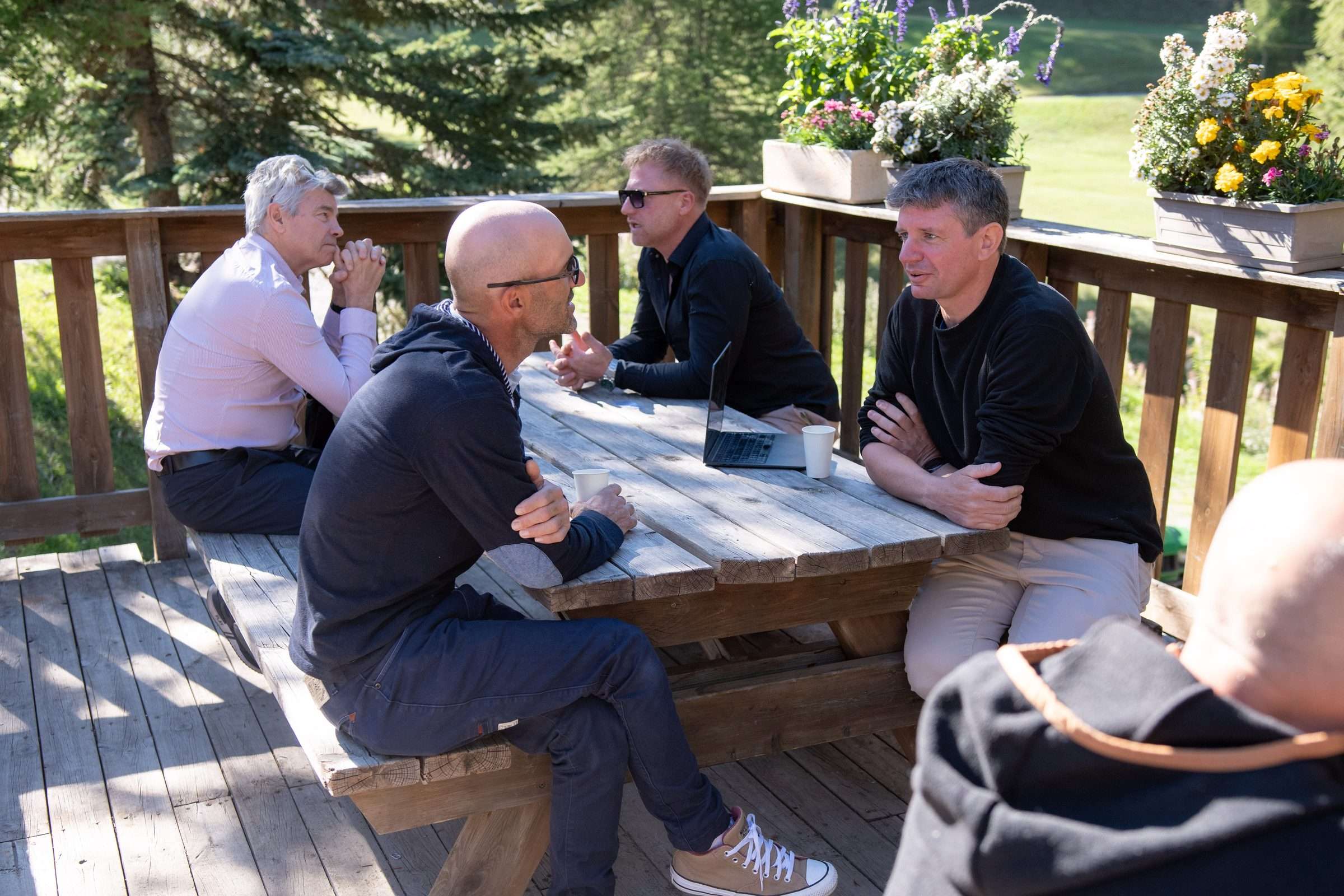 Discussion à quatre autour d’une table en bois