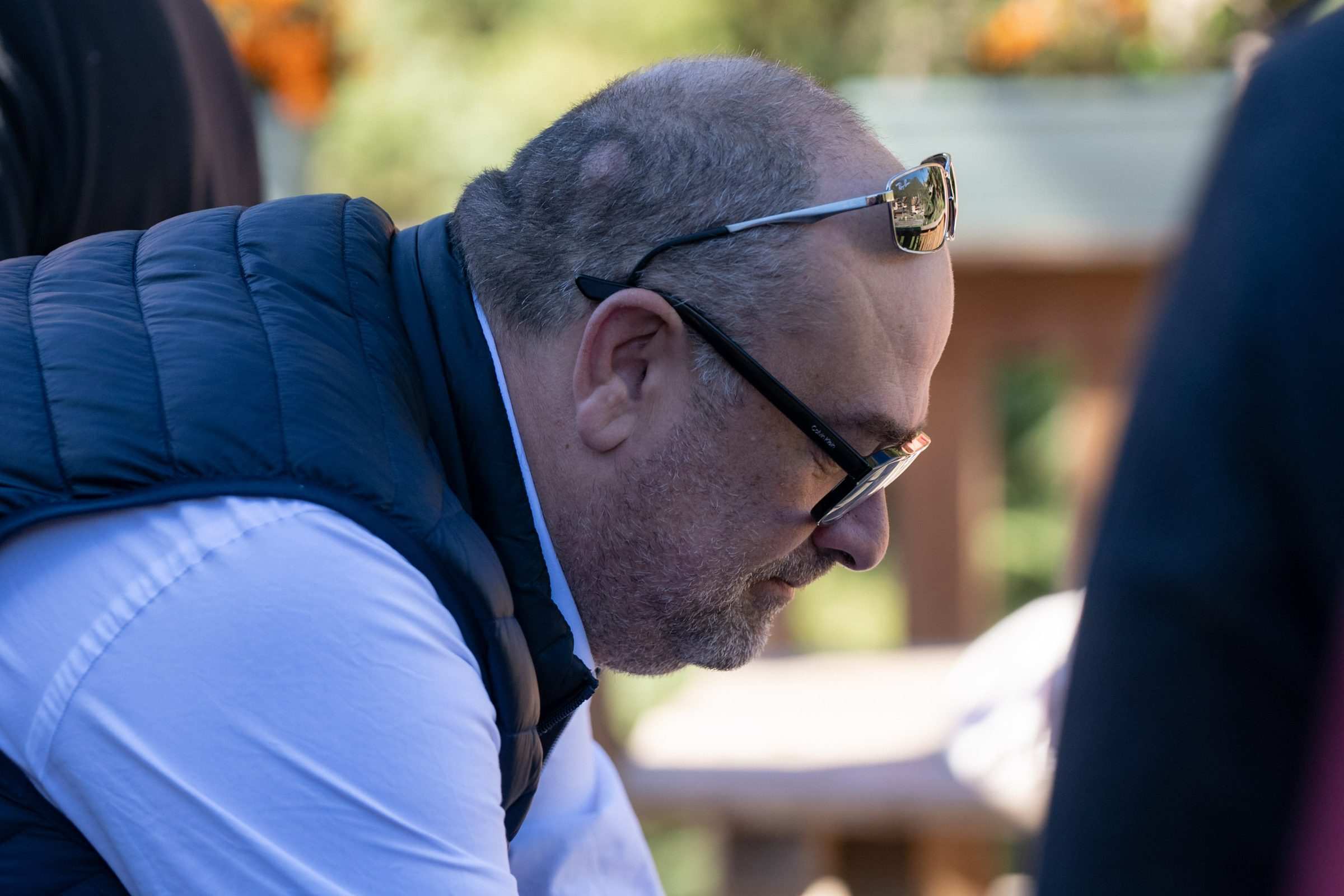 Un participant penché sur la table, lunettes relevées sur la tête