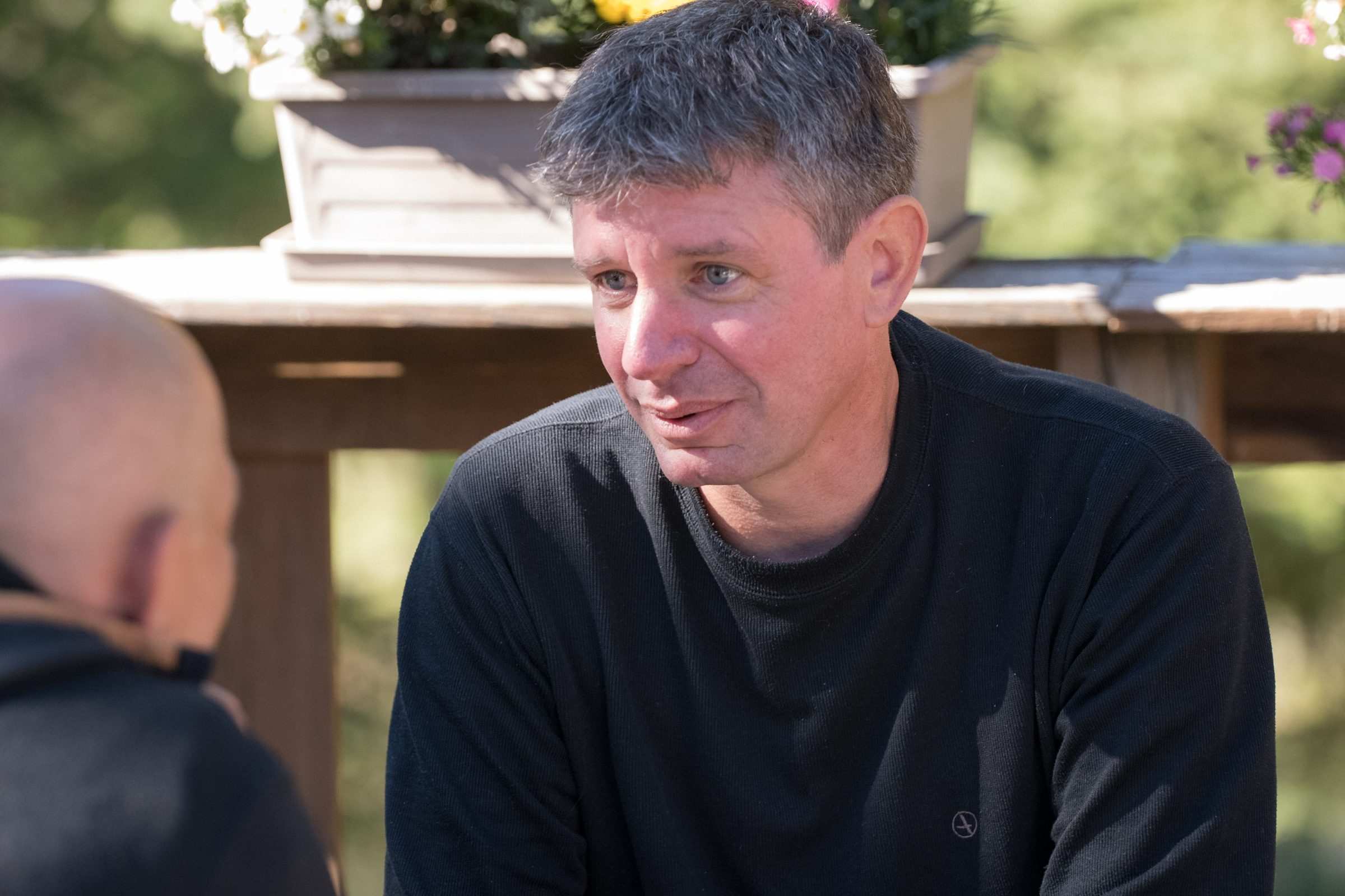 Un participant écoute, attablé sur la terrasse