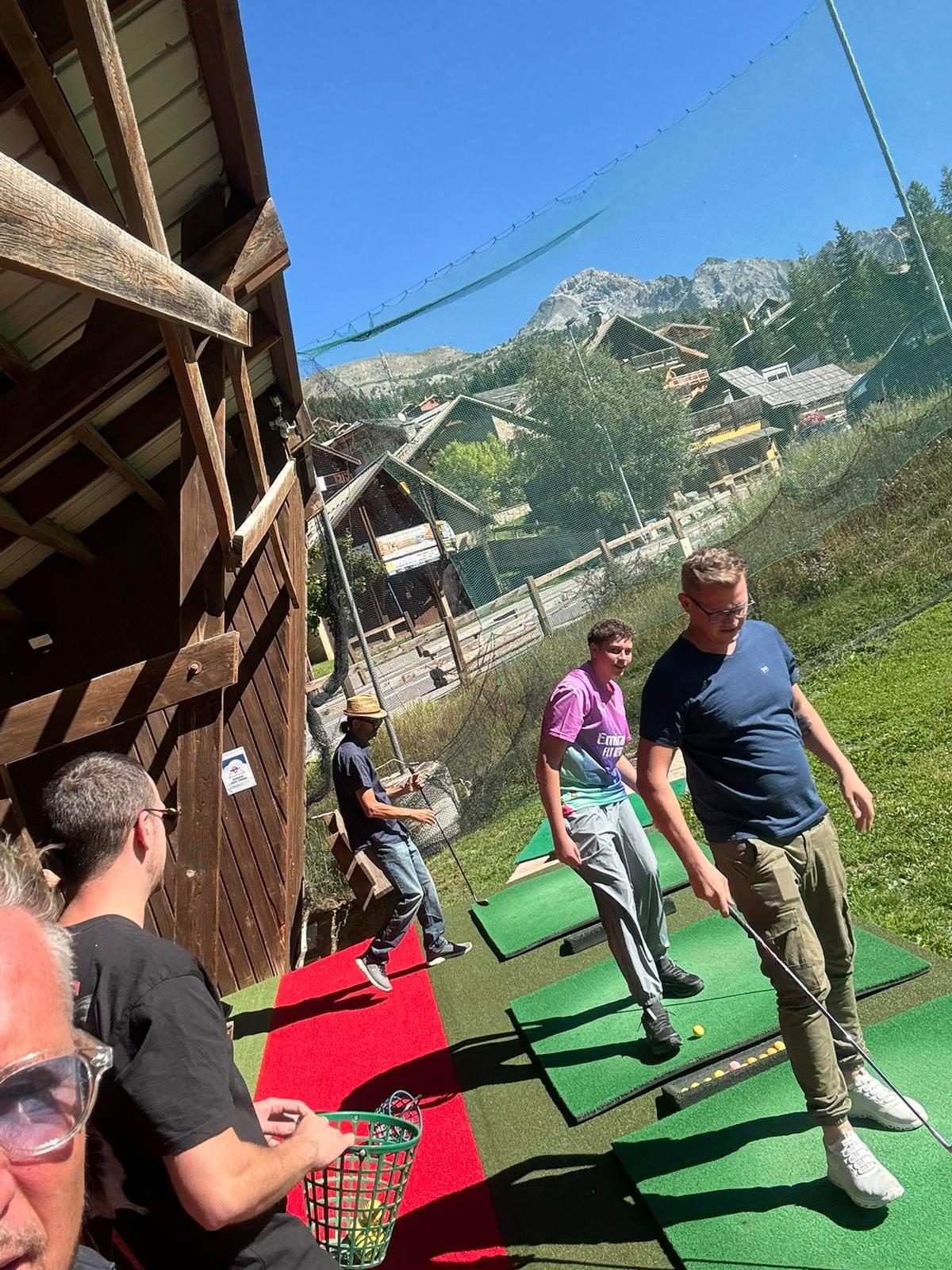 Initiation au practice de golf, face aux montagnes